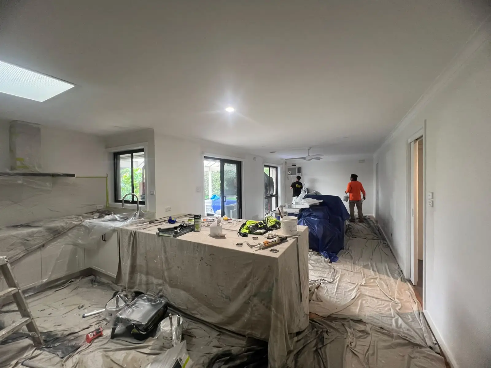 VY Painters rolling premium sage green paint onto a living room wall during a professional wall repainting Melbourne project