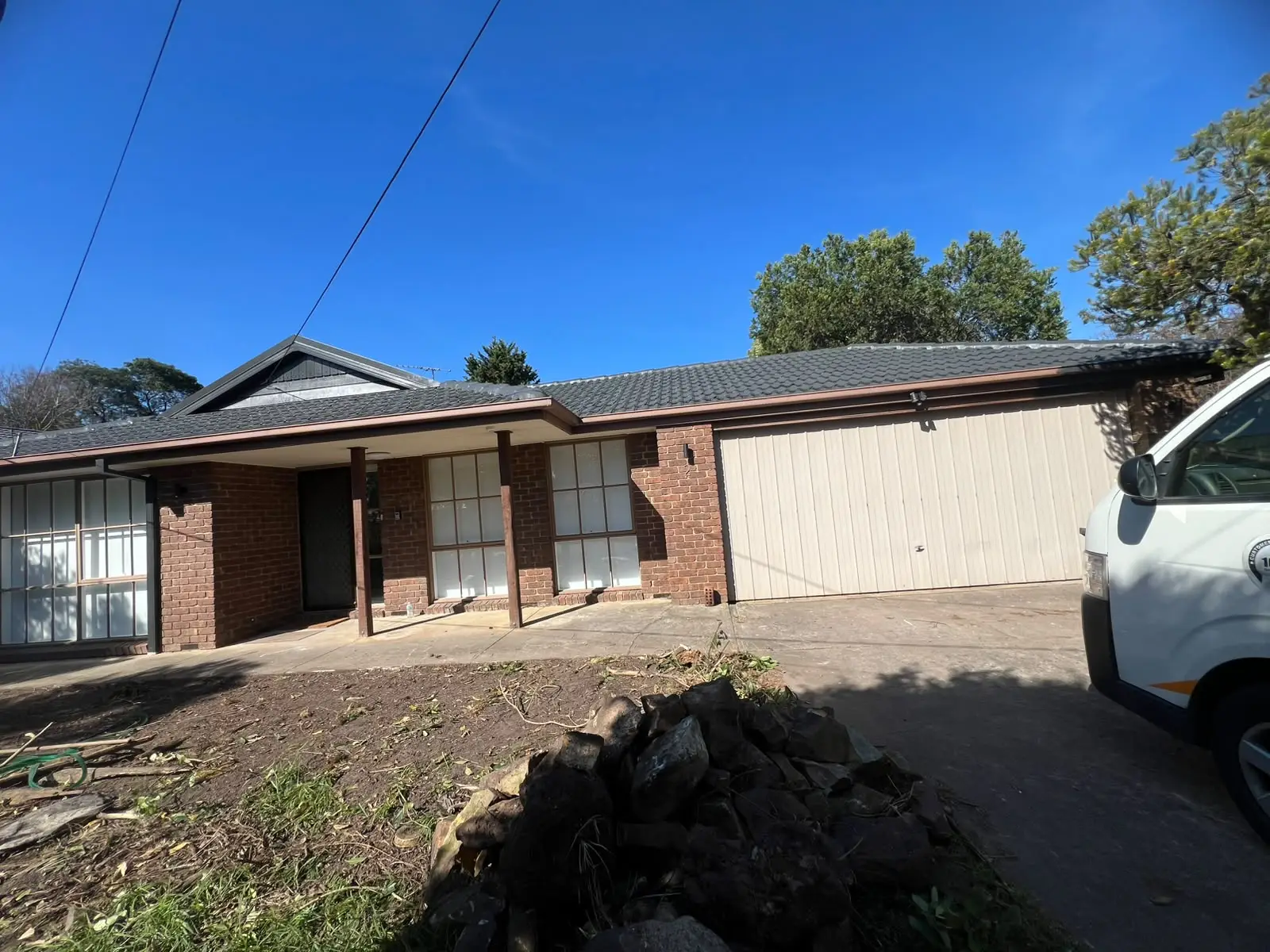 VY Painters repainting a bright Melbourne home interior with a freshly prepared wall, protected flooring, covered furniture, masked trim, and professional painting equipment.